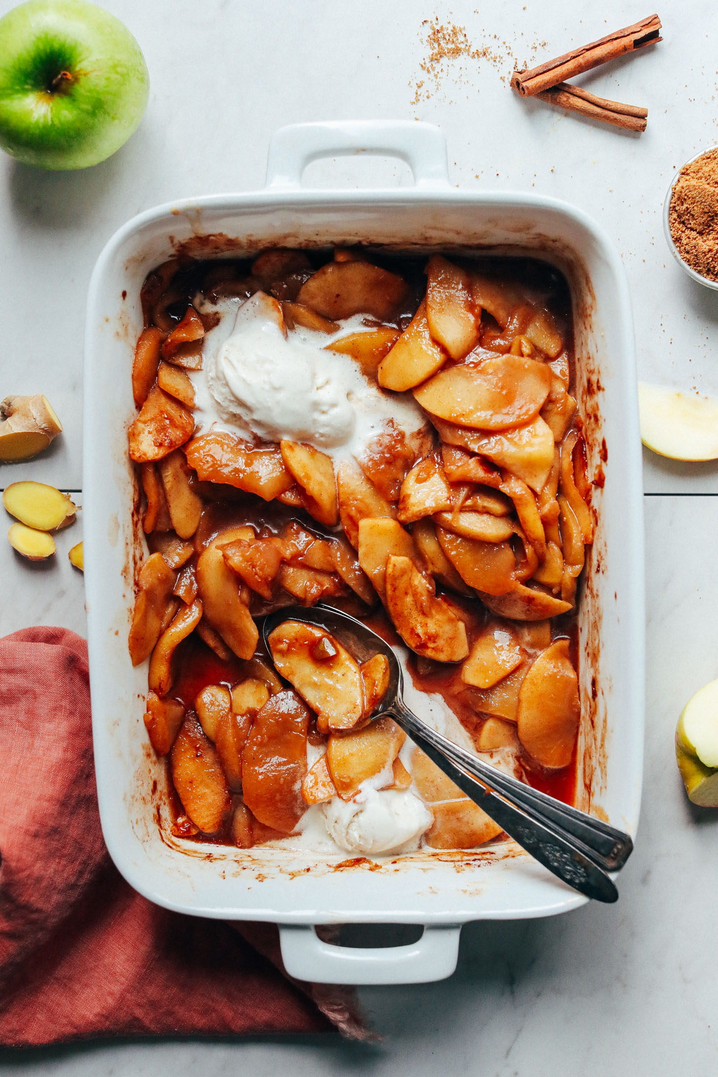 Delicious Cinnamon Baked Apples in a ceramic baking dish with scoops of vegan ice cream