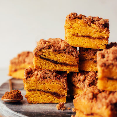 Stack of squares of pumpkin coffee cake with a pumpkin spice swirl and streusel topping