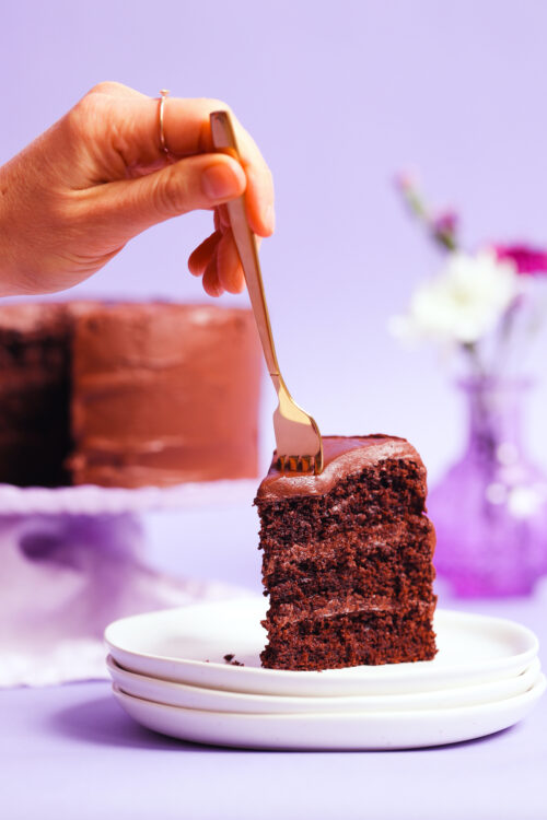 Using a fork to cut into a slice of the best vegan gluten-free chocolate cake
