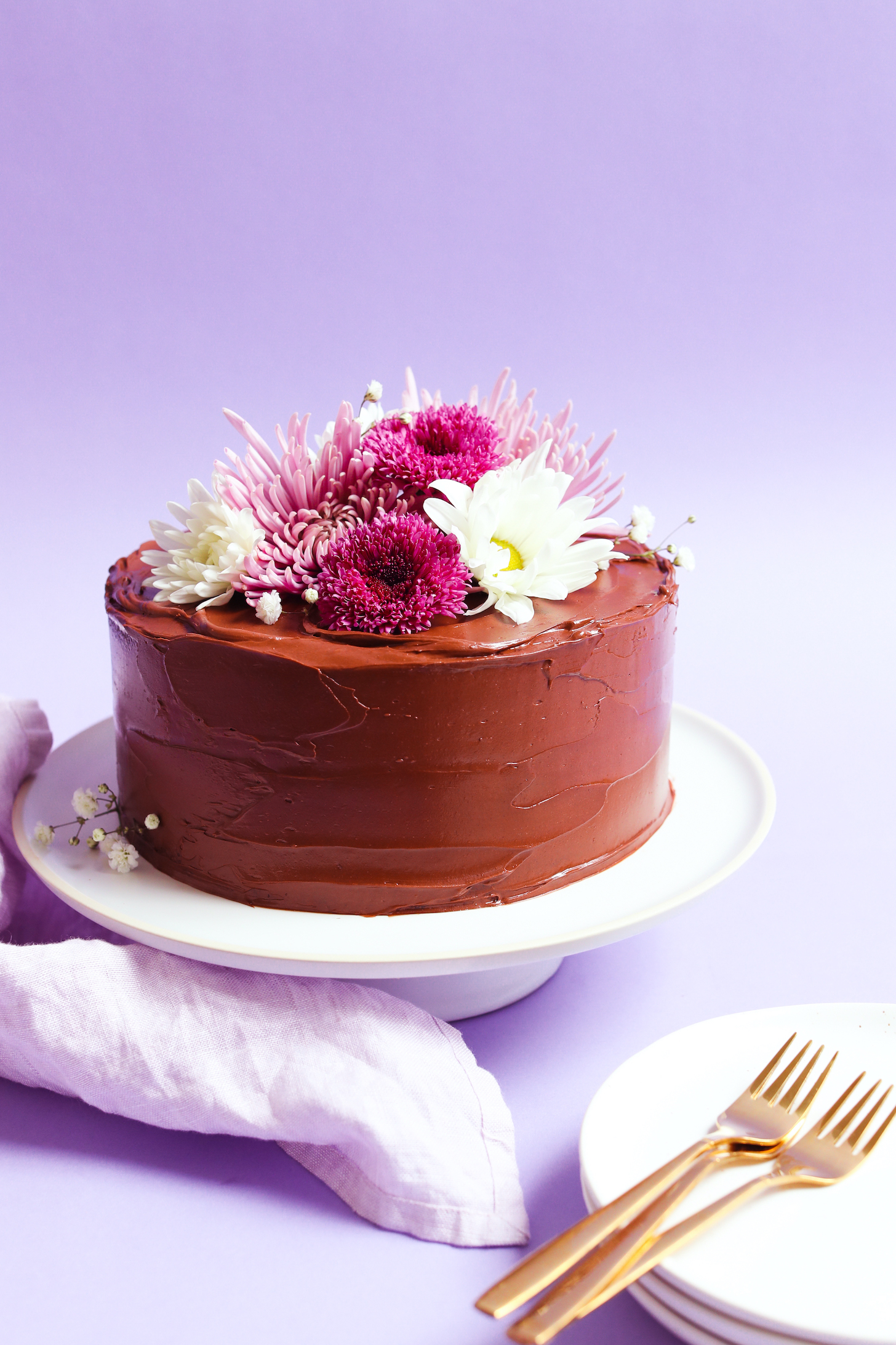 Vegan gluten-free chocolate cake with vegan chocolate ganache frosting and flowers
