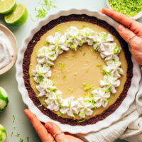Overhead shot of a vegan gluten-free key lime pie topped with dairy-free whipped cream