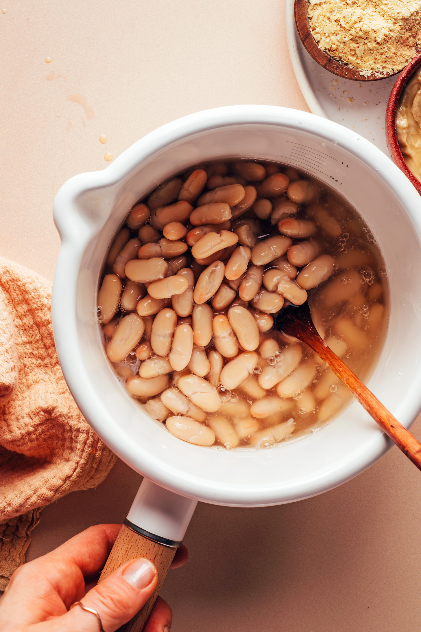 Heating white beans in a saucepan