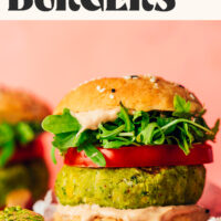 Side view of a pesto veggie burger against a pink background