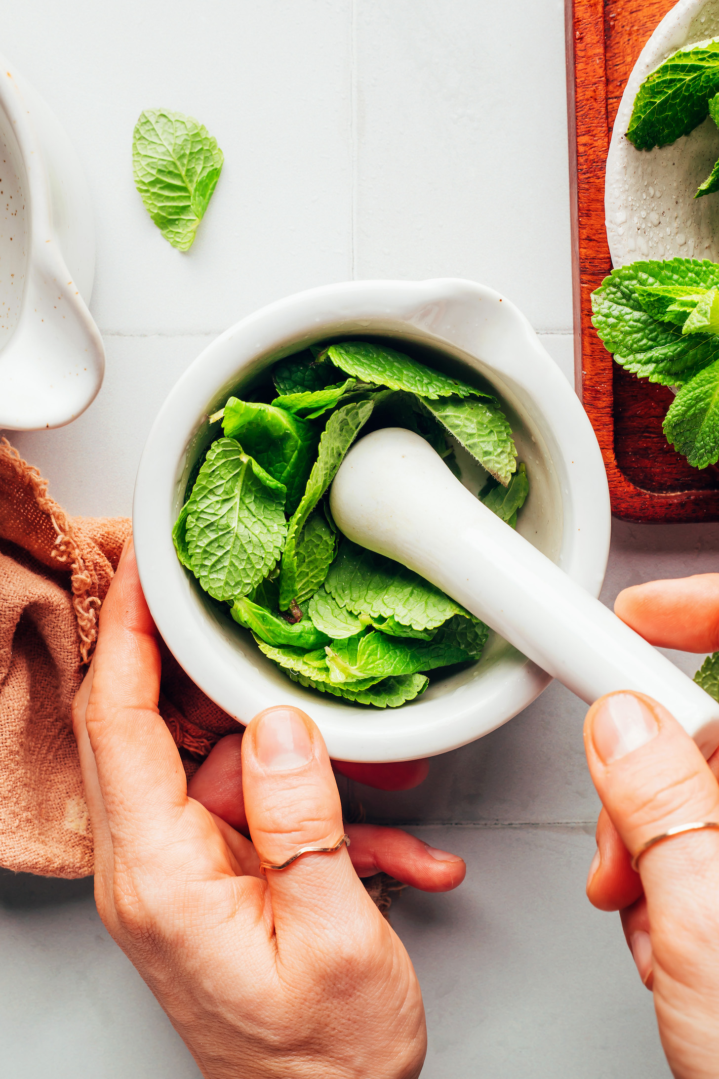 Using a mortar and pestle to muddle mint leaves