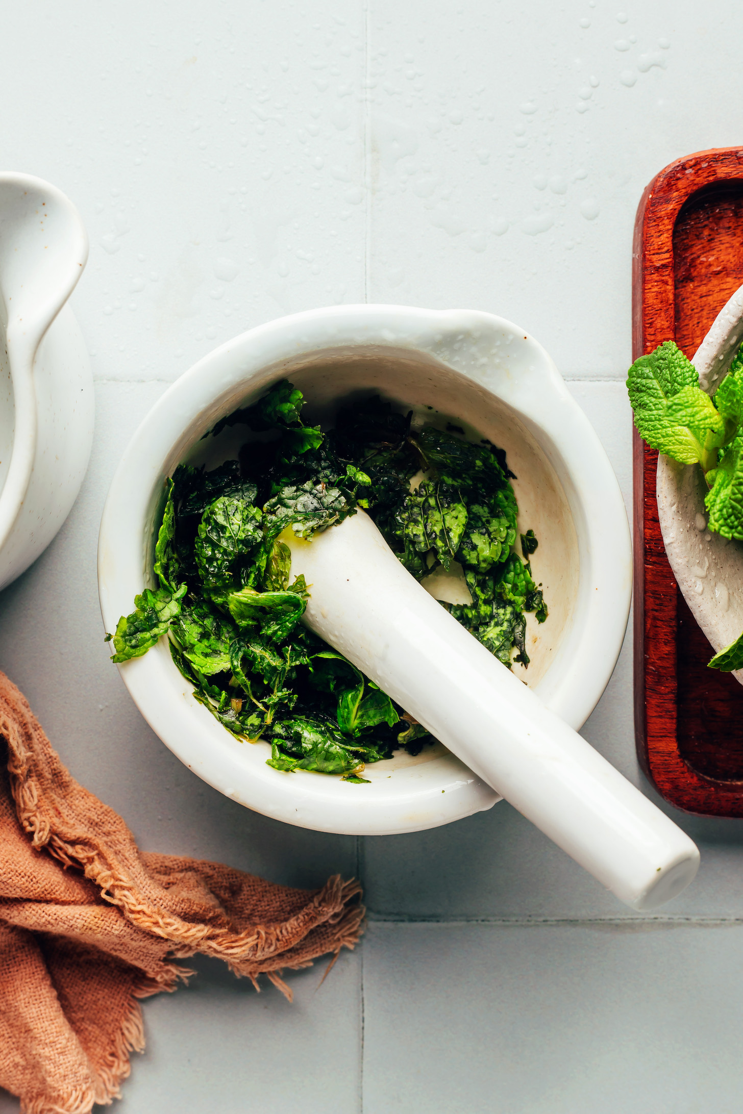 Muddled mint leaves in a mortar and pestle
