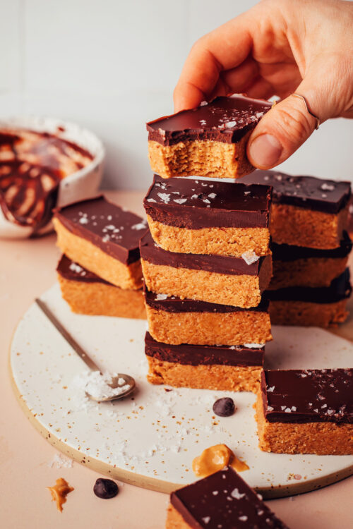 Holding a no-bake peanut butter cup bar over a stack of more bars