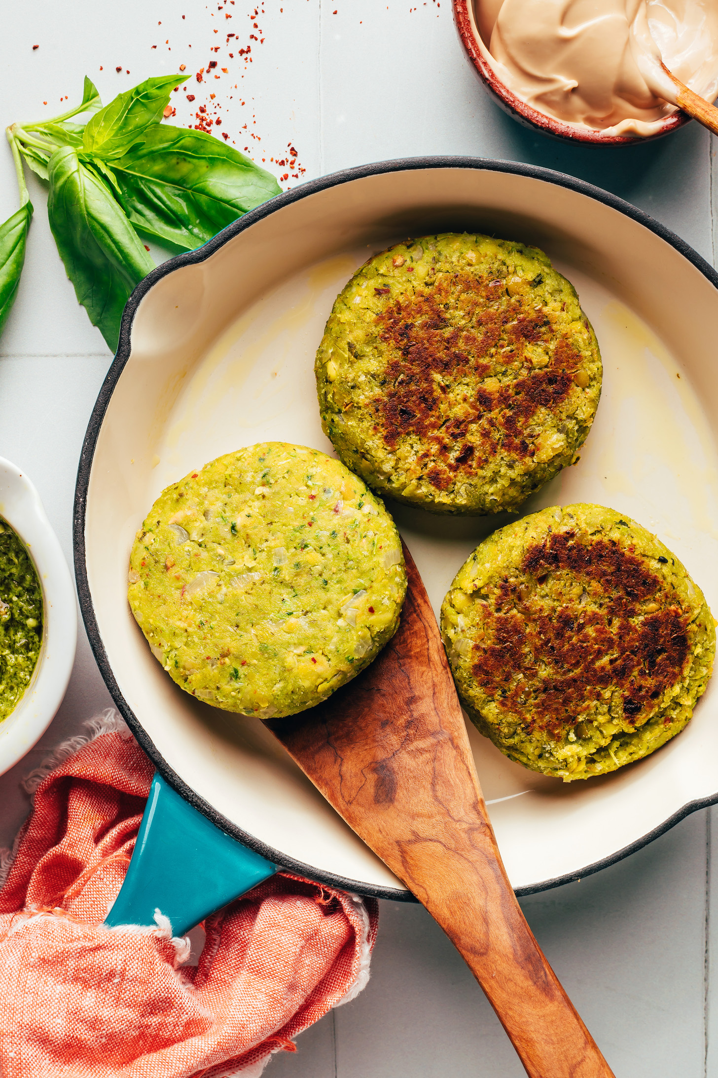 Cooking pesto chickpea veggie burgers in a skillet