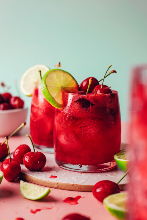 Glasses of sparkling cherry limeade with fresh cherries and limes
