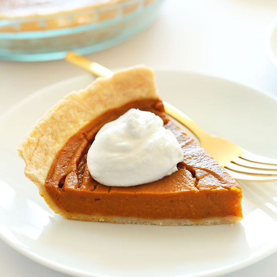 Slice of Vegan GF Pumpkin Pie topped with coconut whipped cream