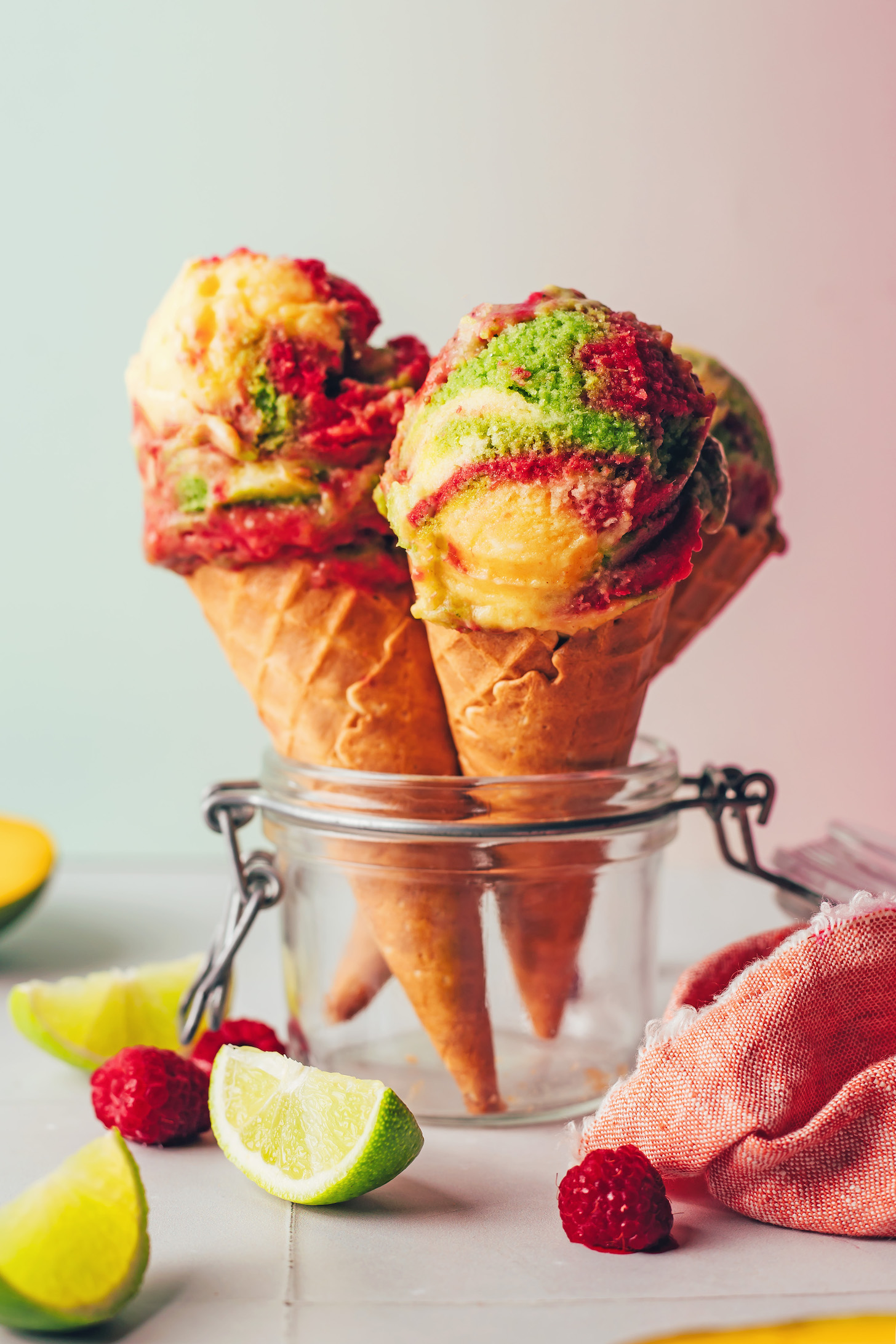 Scoops of vegan rainbow sherbet ice cream in cones