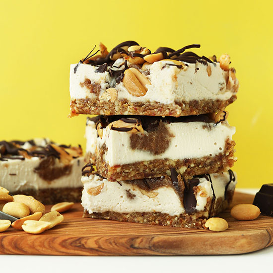 Stack of squares of homemade Vegan Snickers Cheesecake
